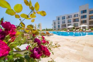 a hotel with a pool and flowers in the foreground at Diamond Beach Apartment 2 Room in Burgas City