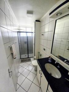 a bathroom with a sink and a toilet and a shower at Apto 2 Quartos, pertíssimo da Beira-Mar e Ponte HL in Florianópolis