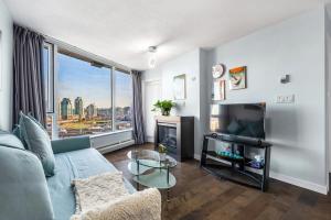 a living room with a couch and a tv at Downtown 1 Bedroom Water View Condo in Vancouver