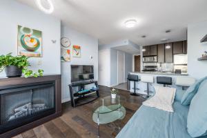 a living room with a couch and a fireplace at Downtown 1 Bedroom Water View Condo in Vancouver
