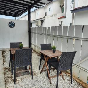 a wooden table and chairs on a patio at Prima Guest House - Puncak Alam Homestay Mus-lim friendly in Bandar Puncak Alam