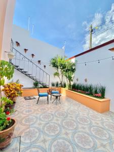- une terrasse avec 2 chaises et une table dans un bâtiment dans l'établissement Iluminada y confortable habitaciones en Casa Margarita Oaxaca, à Oaxaca