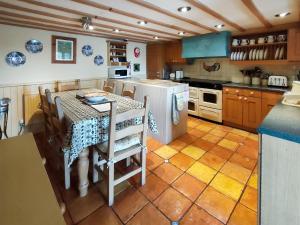 a kitchen with a table and a white refrigerator at Sunnyhill in Brigsteer