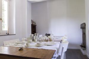 Il Fiume Azzurro Home B&B في كاستيلّيتّو سوبرا تيسان: غرفة طعام بيضاء مع طاولة وكراسي بيضاء