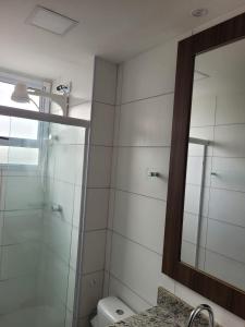 ein Bad mit einer Dusche und einem Spiegel in der Unterkunft Residencial Jardim da costa in João Pessoa