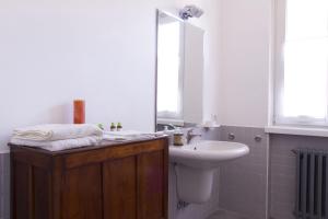 bagno con lavandino e servizi igienici bianchi di Il Fiume Azzurro Home B&B a Castelletto sopra Ticino