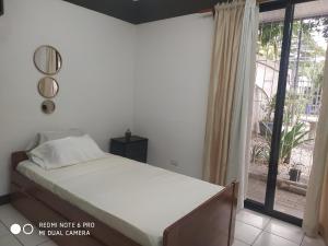 ein Schlafzimmer mit einem Bett und einem großen Fenster in der Unterkunft Villa Zurí in Guanacaste