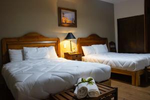 Hotel Casa del Fraile في موريليا: غرفة في الفندق بسريرين يوجد مناشف على طاولة