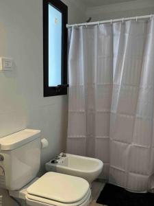 uma casa de banho com um WC e uma cortina de chuveiro em 57 entre 24 y 25, La Plata. Alquiler temporario. em La Plata