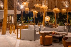 a living room with couches and tables and chandeliers at Menjaga Bay in Labuan Bajo