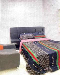 a bedroom with two beds and a chair at DIVINE VILLA AND RESORTS HOTEL GUEST House 15 mins Near Michael Okpara University Sam Mbakwe Airport in Umuhu