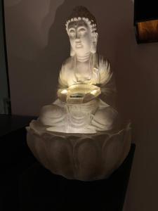 een standbeeld van een Boeddha zittend in een kom bij Elysium: 1-BHK flat near Imagica with shared pool in Pāli