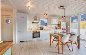 a kitchen with white cabinets and a table and chairs at Nice Home In Wandlitz Ot Zerpenschl in Berg