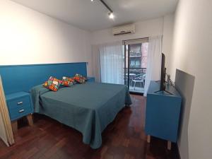 a bedroom with a blue bed and a television at Turismo Apart Palermo in Buenos Aires
