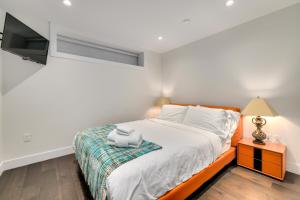 a white bedroom with a bed and a tv at BEB in Vancouver