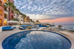a large swimming pool with a view of the ocean at El Encanto All Inclusive Resort in Cabo San Lucas