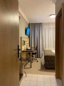 a hotel room with a desk and a bed and a television at Alter Hof in Neukirch +12 photos