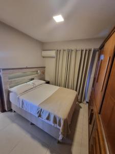 a small bedroom with a bed and a window at Apto luxo de 2 quartos, 3 banheiros Praia do forte in Cabo Frio