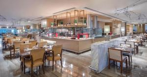 a restaurant with tables and chairs and a counter at Shanghai Hongkou Sanzhi International Hotel in Shanghai