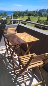 - Balcón con mesa de madera y 2 sillas en Departamento pelluco alto II en Puerto Montt