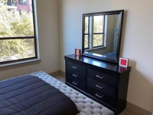 a bedroom with a bed and a dresser with a mirror at H-Town Luxury w/ Pool in Houston