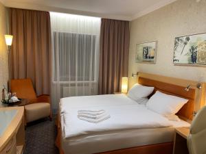 um quarto de hotel com uma cama e uma cadeira em Hotel Alter Hof 