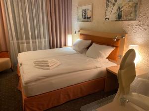 a hotel room with a bed with towels on it at Alter Hof in Neukirch
