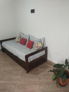 a bed with pillows on it in a room at Depto Otero in San Salvador de Jujuy