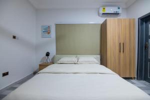 1 dormitorio con 1 cama grande y armario de madera en Big Chill Stays(Texas), en Madina