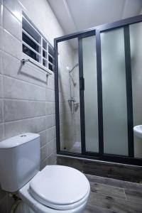 a bathroom with a toilet and a glass shower at Big Chill Stays(Texas) in Madina