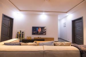 sala de estar con sofá y TV en la pared en Big Chill Stays(Texas), en Madina