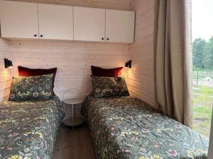 dos camas sentadas una al lado de la otra en una habitación en Holiday homes with sauna and jacuzzi in Trz sacz, en Trzęsacz