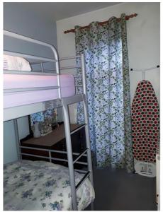 a bedroom with a bunk bed with a surfboard next to a window at Private Annex, Little Flat, Private Entrance in Nottingham