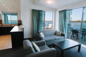 a living room with a couch and a table at Ramada Hotel & Suites by Wyndham Ballina Byron in Ballina