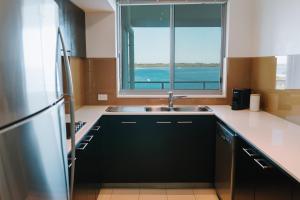 a kitchen with a sink and a large window at Ramada Hotel & Suites by Wyndham Ballina Byron in Ballina