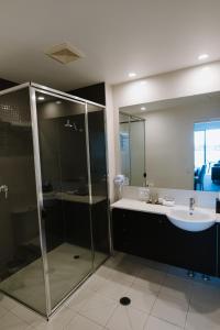 y baño con ducha y lavamanos. en Ramada Hotel & Suites by Wyndham Ballina Byron en Ballina