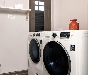 a white washing machine sitting next to a refrigerator at Ann Siang House, The Unlimited Collection managed by The Ascott Limited in Singapore