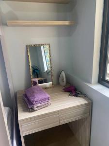 a dressing table with a mirror and purple towels on it at 3 Beds Filinvest Alabang in Manila
