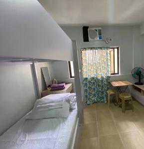 a bedroom with a bed and a desk and a window at 3 Beds Filinvest Alabang in Manila