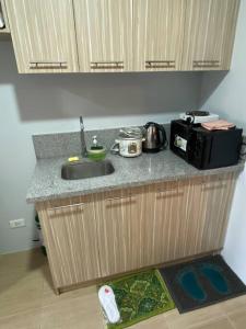 a kitchen counter with a sink and a microwave at 3 Beds Filinvest Alabang in Manila