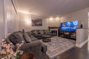 uma sala de estar com um sofá e uma televisão de ecrã plano em SABAA em Ottawa