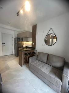 a living room with a couch and a kitchen at Flat Encantador Allianz Park 607 in Sao Paulo