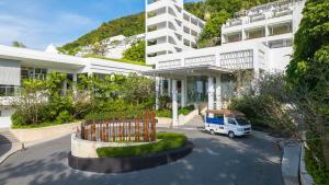 a white van parked in a parking lot in front of a building at The Nai Harn in Nai Harn Beach