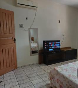 um quarto com uma televisão, uma porta e um espelho em Suite em ótima localização em Santarém