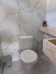 uma casa de banho branca com um WC e um lavatório em Suite em ótima localização em Santarém