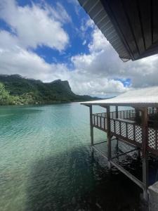 a dock in the water with a view of the ocean at Taina - dans la baie de Faaroa in Taputapuapea