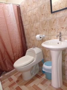 a bathroom with a toilet and a sink at Nambí Rooms in Nambí