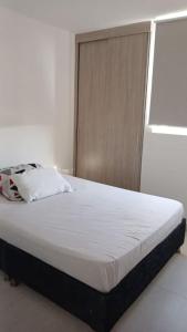 Bett in einem weißen Zimmer mit einem weißen Bett sidx sidx sidx in der Unterkunft apartamento en santa marta in Nuevo Amanecer