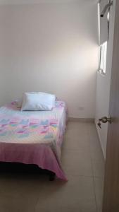 1 dormitorio con cama con almohada en apartamento en santa marta, en Nuevo Amanecer