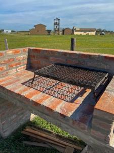 a brick bench with a grill on top of a field at La Escapada, cabaña en San Miguel del Monte in San Miguel del Monte